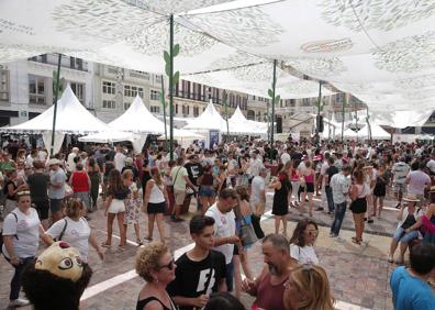 Imagen secundaria 1 - Un biznaguero apura las últimas horas de feria en calle Larios, donde se cruza con feriantes y con turistas que dicen adiós. Aspecto de la plaza de la Constitución, ayer al mediodía, con un público que aunque menos numeroso no quiso dejar escapar las últimas horas de fiesta. Una joven vestida de corto sirve a la manera tradicional un vino dulce. 