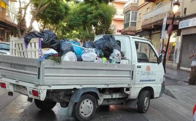 Camión municipal recogiendo residuos. 
