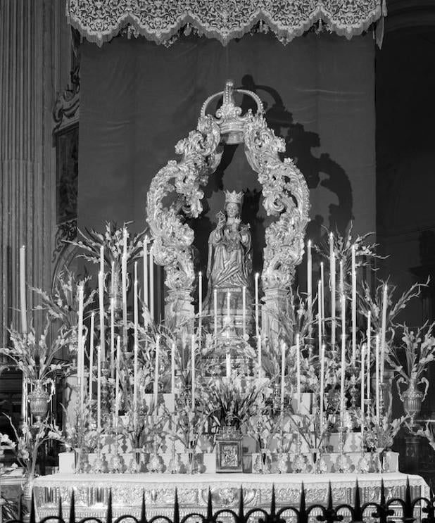 Durante varios años, el altar de la novena se situó en uno de los laterales del altar mayor de la Catedral. La imagen aparece en esta fotografía cobijada por un vistoso templete de madera dorada y arropada por el dosel que bordaran las monjas adoratrices, todavía sin finalizar. / Fondo Bienvenido-Arenas. 