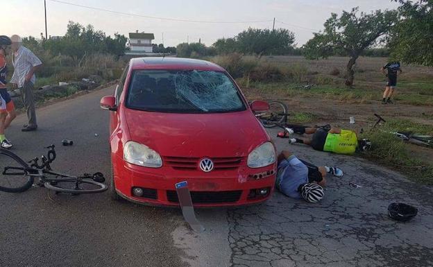 Imagen de dos de los heridos en el accidente, junto al coche que los ha arrollado. 