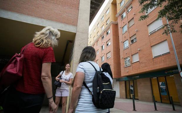 Un grupo de vecinos conversa en el lugar donde dos niñas de 2 y 6 años han sido asesinadas a cuchilladas en la ciudad de Castellón. 