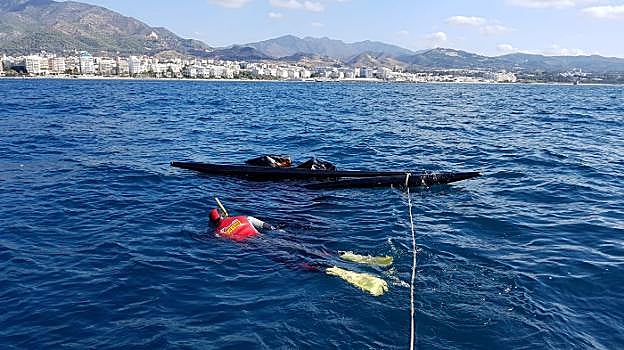 Un bombero de Marbella, junto a la embarcación. 