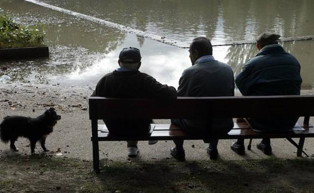 Jubilados descansan en el banco de un parque. 