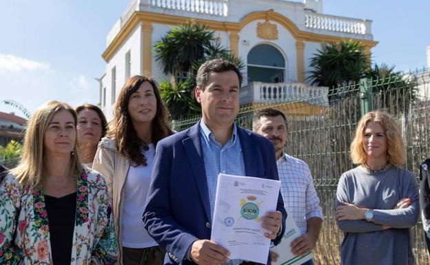 Juanma Moreno, junto a varios dirigentes de su partido, muestra hoy frente al Club Don Angelo de Sevilla