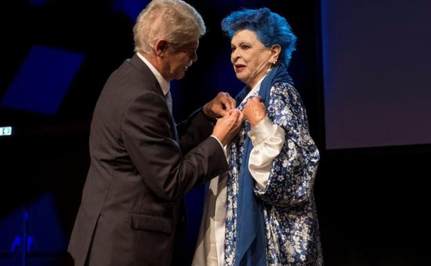 La artista italiana Lucía Bosé es premiada por el embajador español en Italia, Alfonso Dastis.