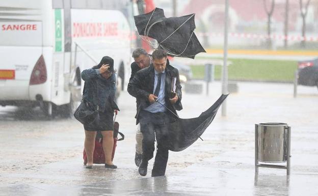 Peatones durante la tormenta esta mañana en Málaga capital. 