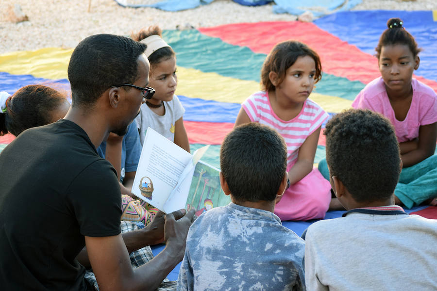 Voluntario leyendo un cuento a los niños de la biblioteca de Smara.