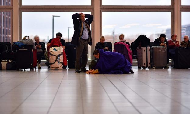 Pasajeros entretienen la espera en el edificio de la Terminal Sur del aeropuerto de Gatwick mientras las salidas continúan demoradas. :: Ben STANSALL / AFP