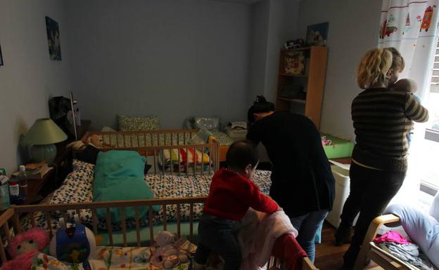 Varias mujeres atienden a sus hijos en un piso de acogida.