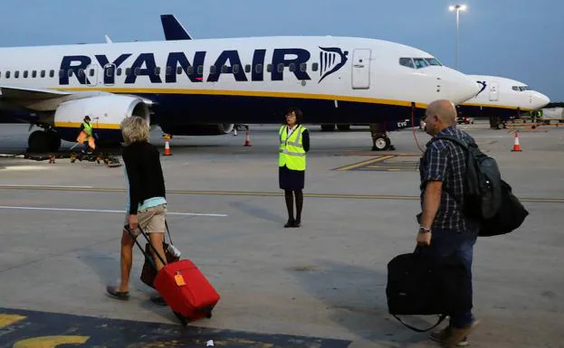 Viajeros se dirigen hacia el avión de la compañía Ryanair.