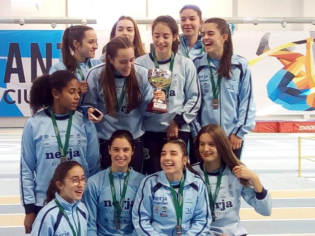 Las integrantes del conjunto femenino del Cueva de Nerja-UMA, en el podio con el trofeo.:: sur
