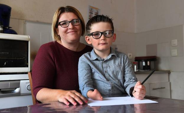 Un niño con malformaciones en los brazos nacido hace seis años en la región francesa de Ain, con su madre en la cocina de su casa. 