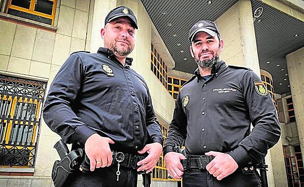 El oficial Francisco Martín (izquierda, junto a su compañero Álvaro López, en comisaría. 