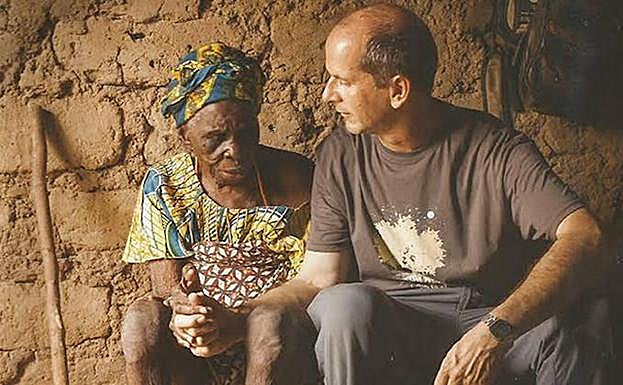 El misionero riojano Juan Pablo López acompaña a una anciana de Benín. 
