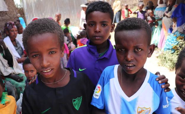 Imagen principal - Arriba, varios niños con las camisetas del Málaga. Abajo, algunas voluntarias de Harena. 