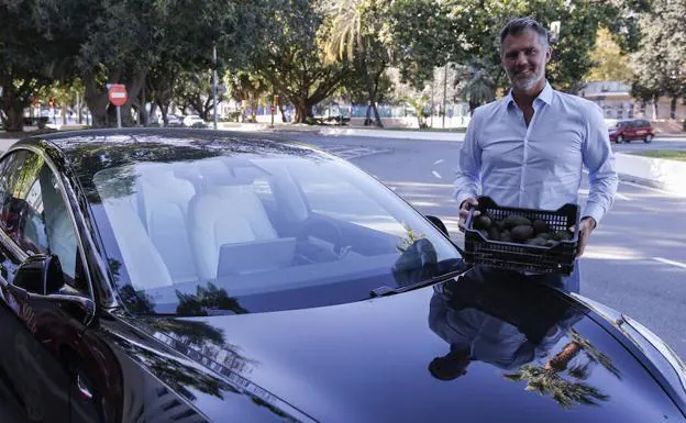 Pelle Lundborg, junto a su automóvil Tesla y una muestra de los aguacates que lleva.