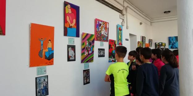 Alumnos observan varias de las obras realizadas. 