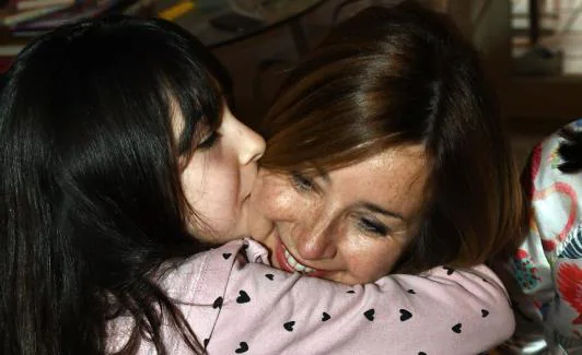 La madre abraza a su hija en el salón de la casa familiar, en Marbella. 