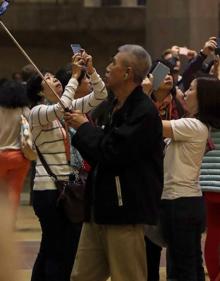 Imagen secundaria 2 - Arriba, la construcción, a principios del siglo XX. Abajo, a la izquierda, autobús turístico en el barrio donde se ubica el templo. A la derecha, un grupo de japoneses fotografían la basílica. :: efe
