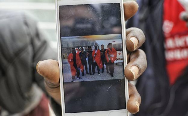 Refugiados senegaleses en Bilbao muestran una imagen de su llegada a puerto. 