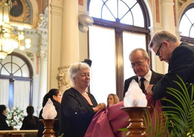 Imagen secundaria 1 - Málaga da su último adiós al poeta y articulista Manuel Alcántara. Francisco de la Torre, ha entregado la bandera de Málaga, que ha cubierto el féretro, a la hija de Manuel Alcántara Lola Porras