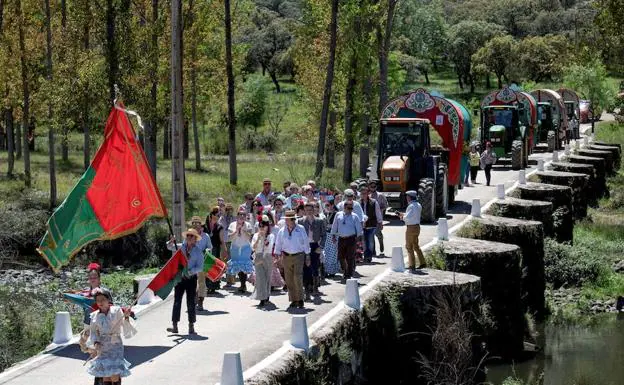 Las peñas romeras cruzan el Puente Viejo que conduce a Lugar Nuevo.