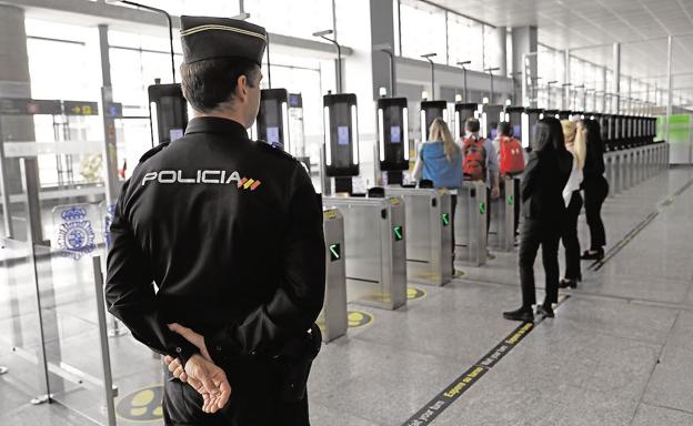 Un policía supervisa en el aeropuerto los nuevos controles automáticos de pasaporte. 