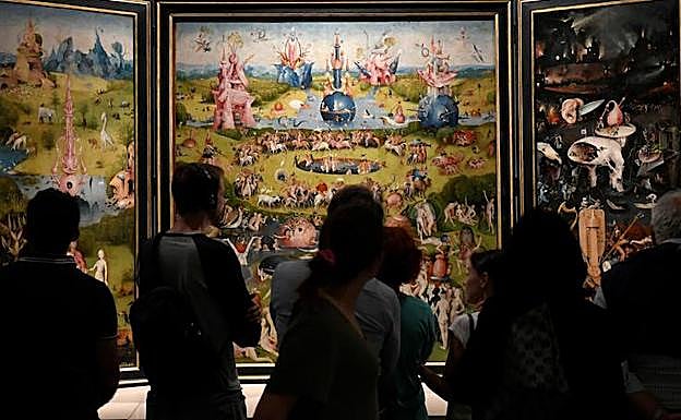 Visitantes observan El jardín de las Delicias, de El Bosco, en el Museo del Prado. 