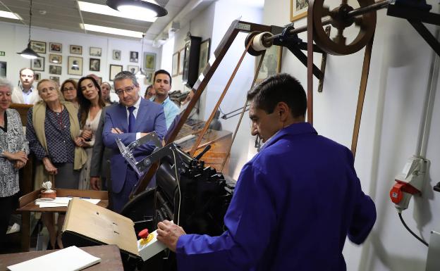 El impresor Pepe Andrade pone en marcha la Monopol Minerva ante la mirada de Lola Alcántara, María Victoria Atencia y Francisco Salado. 