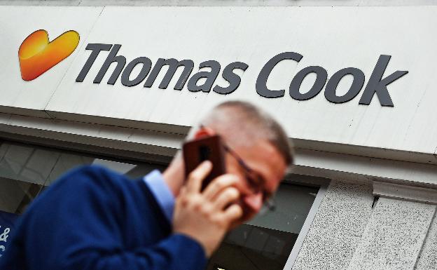 Un viandante pasa frente a un establecimiento de Thomas Cook. 