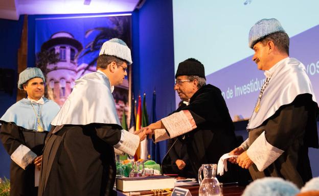 El rector felicita a uno de los nuevos doctores por la UMA. 