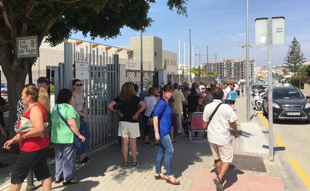 Vecinos, haciendo cola este lunes a la entrada del recinto deportivo. 