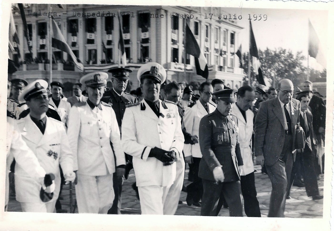 El conde Ciano, en el centro, junto al ministro y yerno de Franco, Ramón Serrano Suñer, a su derecha. Detrás, el edificio de la Autoridad Portuaria engalanado con banderas italianas. (Archivo del Autor)