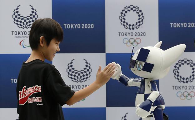 Imagen principal - 1. Miraitowa, la mascota robotizada, saluda a un niño. (EFE) / 2. El Ariake Arena no estará listo hasta diciembre. (AFP) / 3. Ensayos con autobuses autónomos en el aeropuerto. (AFP)