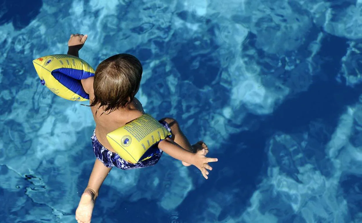 Niño salta al agua en una piscina pública (archivo).