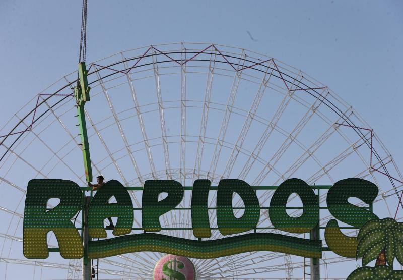 Feriantes, operarios municipales y de contratas y peñistas llevan semanas afanados en poner a punto todos los elementos que conforman esa ciudad efímera que es el Real de Cortijo de Torres.