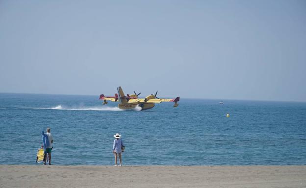 Un hidroavión coge agua del mar.