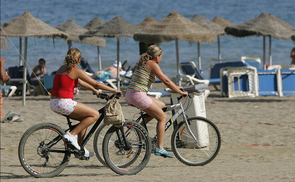 Turistas pasean por una playa de Málaga.