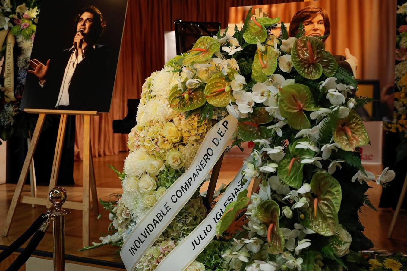Una corona de flores enviada por Julio Iglesias decora la capilla ardiente de Camilo Sesto.