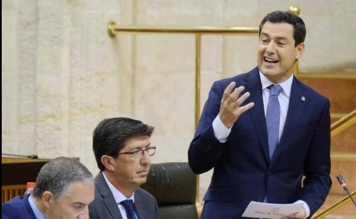 El presidente de la Junta, Juanma Moreno (d), en una de sus intervenciones en el pleno del Parlamento andaluz,