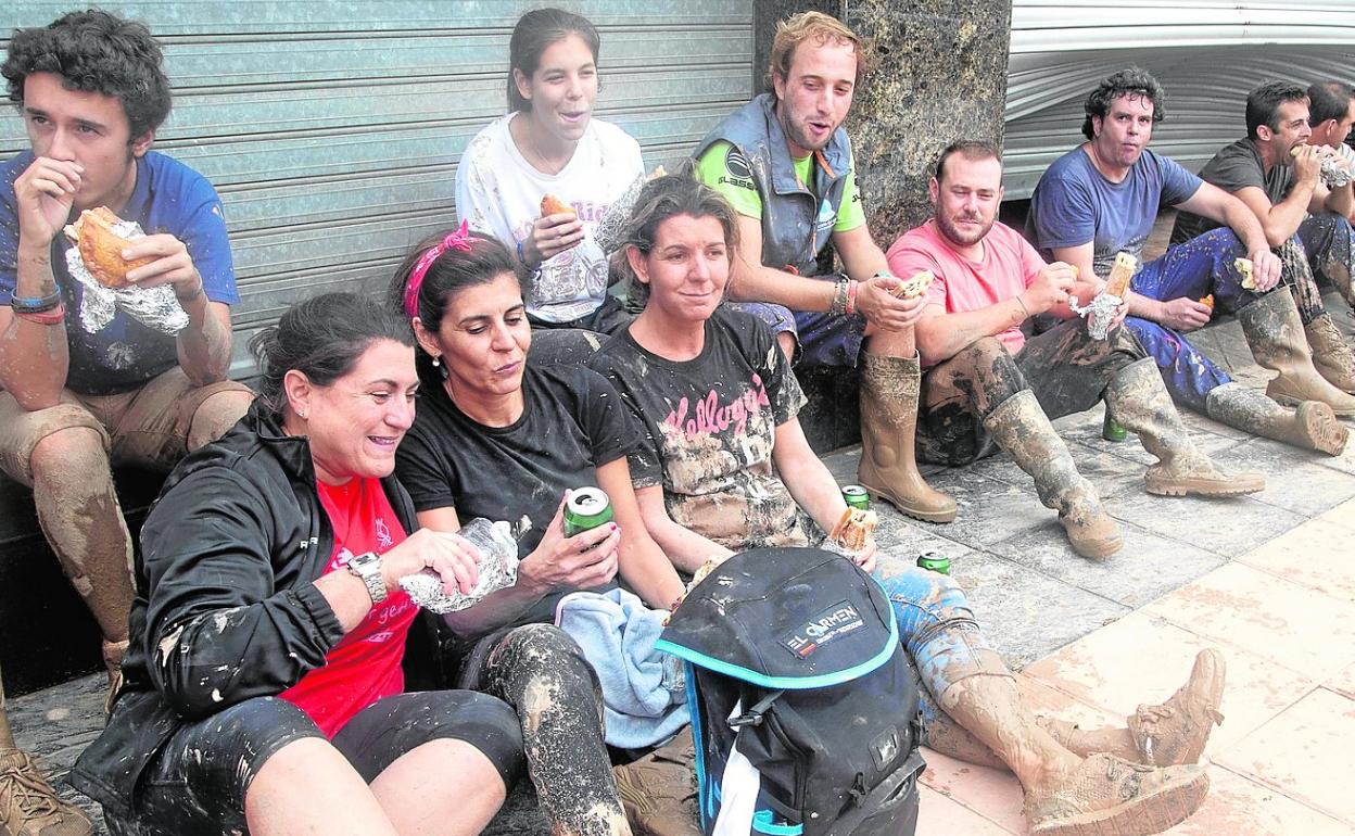 Un grupo de vecinos de Los Alcázares (Murcia) toma un descanso durante las tareas de achique.