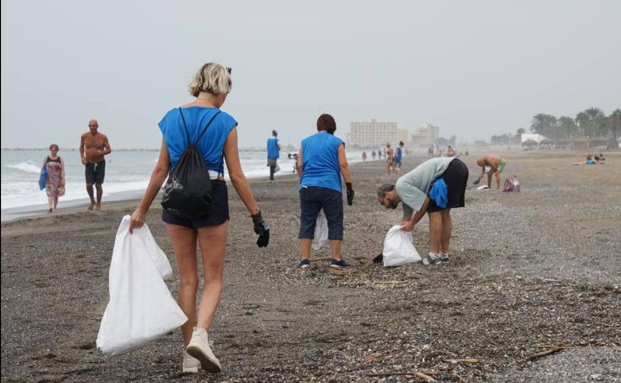 Una treintena de voluntarios se congrega en la Misericordia para limpiar la playa