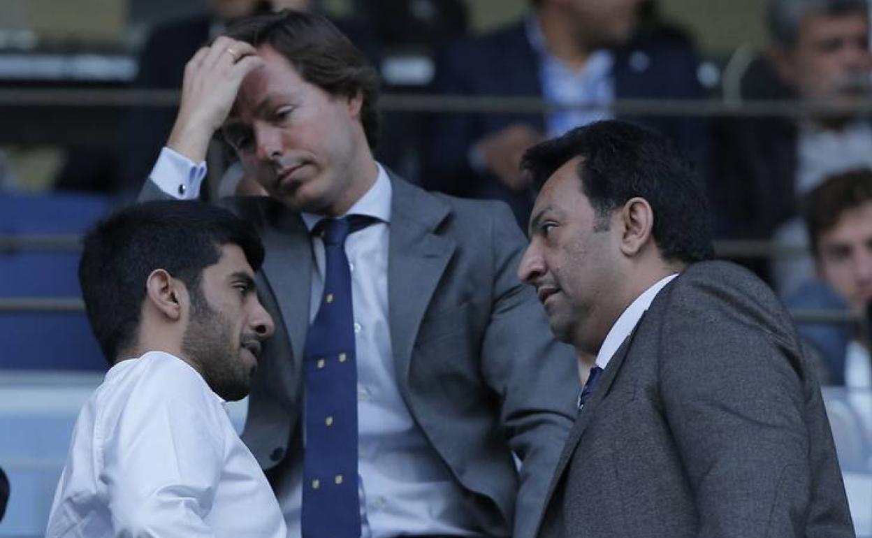 El jeque Al-Thani conversa con su hijo Nasser, con Jofre al fondo, en el palco de La Rosaleda. 
