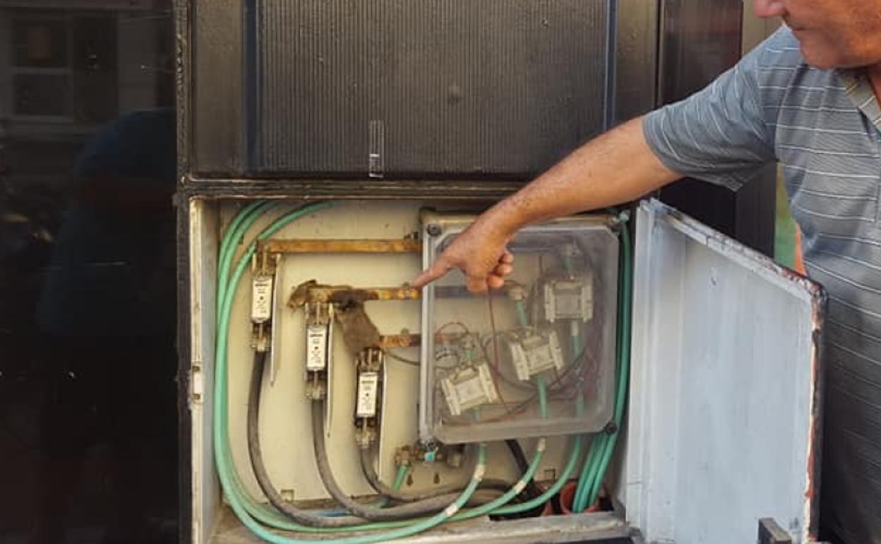 Un vecino señala a la rata atrapada y quemada por la descarga eléctrica.