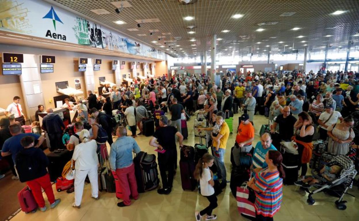Thomas Cook passengers queue in front of check-in desks on the second day of repatriations at Reus airport,