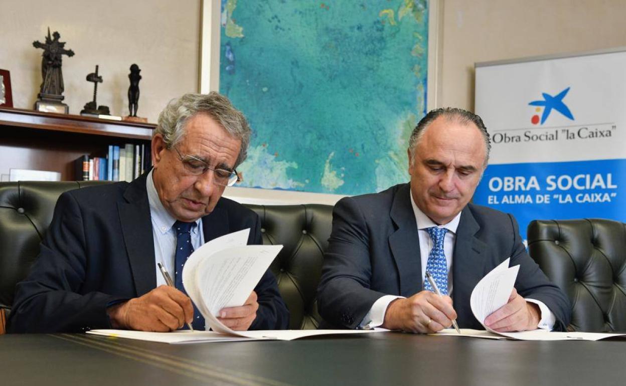 El rector, José Ángel Narváez, y el director territorial de La Caixa, Juan Ignacio Zafra, firman el convenio de colaboración. 