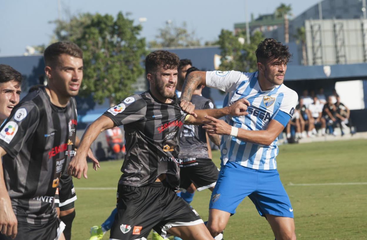 Mini, capitán del Atlético malagueño, en una porfía con un jugador del Antequera. :: francis silva