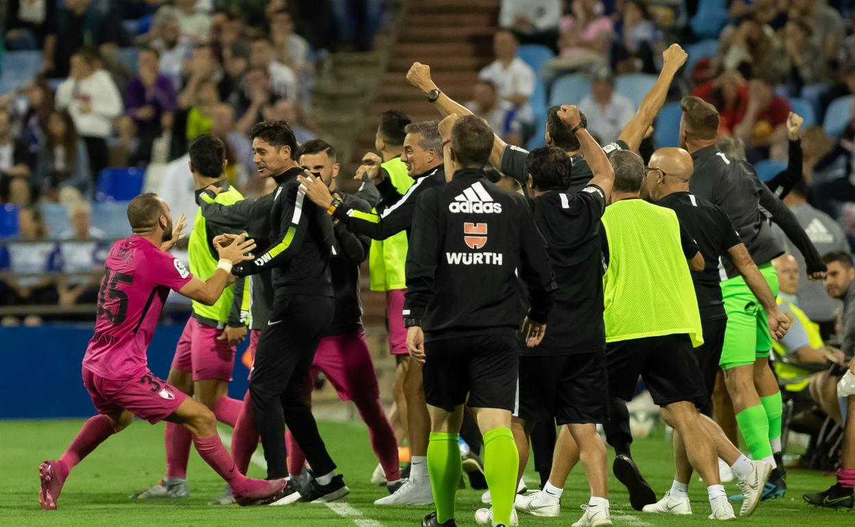 Los malaguistas celebran el 1-2 cerca del área tecnica. 