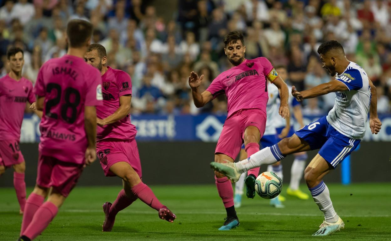 Un remate de Luis Suárez, autor de uno de los goles, que trata de obstaculizar Adrián.