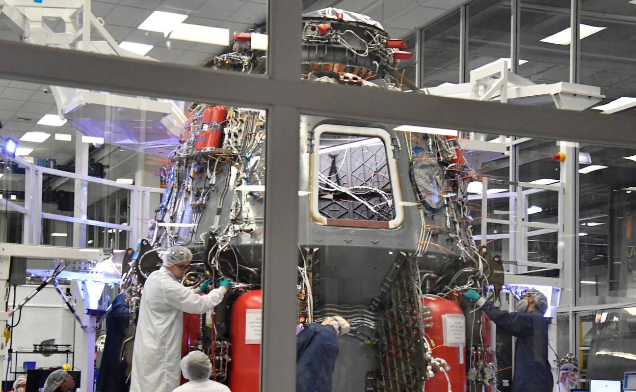 Los técnicos trabajan en la nave Crew Dragon de Space X, que llevará astronautas a la Estación Espacial Internacional.